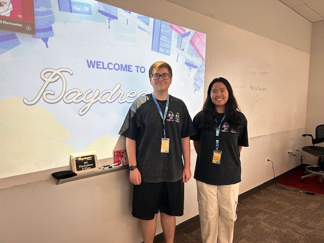  Two students, Ronin and Tracy, stand in front of a projection that says "welcome to daydream".