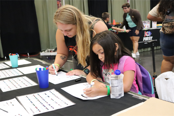  Student and parent writing on a piece of paper at the Back to School Bash