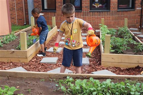 student watering garden