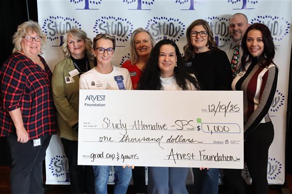  Women and one man pose with a large check for $1,000 to Study Alternative from Arvest Foundation.