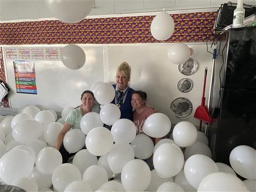 Teachers with principal in balloons