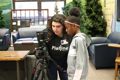 Student looking at camera with Plotline employee 