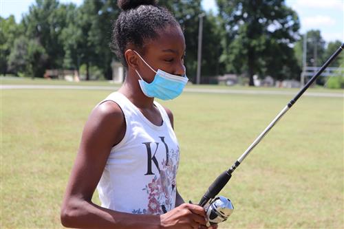 Student in mask practicing fishing 